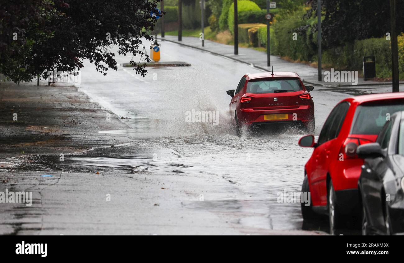 Lurgan, Comté d'Armagh, Irlande du Nord, Royaume-Uni. 04 juillet 2023. Météo au Royaume-Uni - un après-midi de fortes averses lentes. La pluie, torrentielle parfois a causé des inondations localisées où les drains étaient dépassés - la circulation automobile négociant des inondations sur la route principale à Lurgan depuis l'autoroute M1. Crédit : CAZIMB/Alamy Live News. Banque D'Images