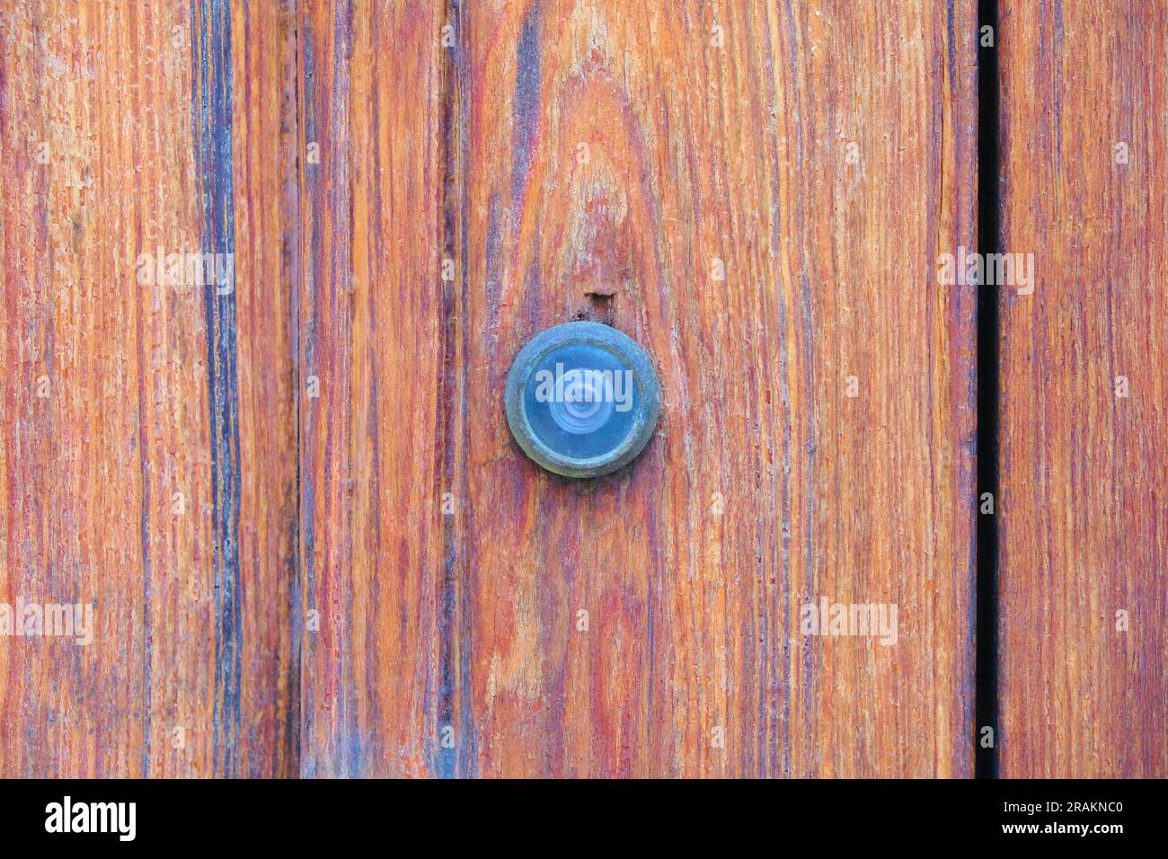 Une éphole dans une porte en bois verni. Banque D'Images