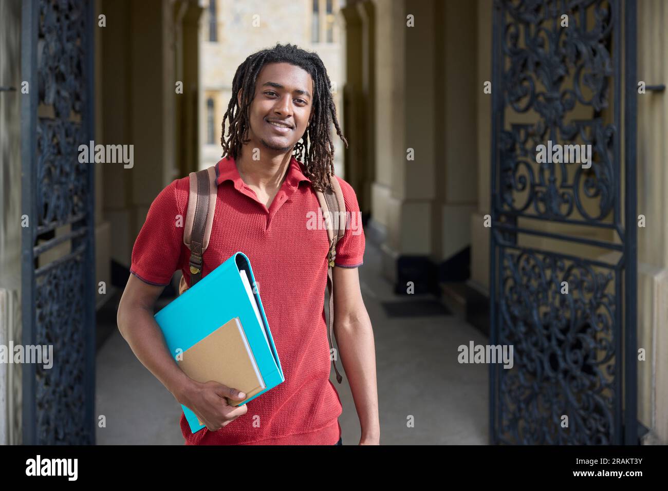 Portrait d'un étudiant portant des dossiers à l'extérieur du bâtiment de l'université d'Oxford, au Royaume-Uni Banque D'Images