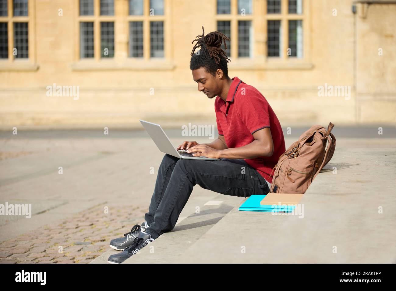 Un étudiant travaillant sur un ordinateur portable assis dans le bâtiment universitaire de StepsOutside à Oxford, Royaume-Uni Banque D'Images