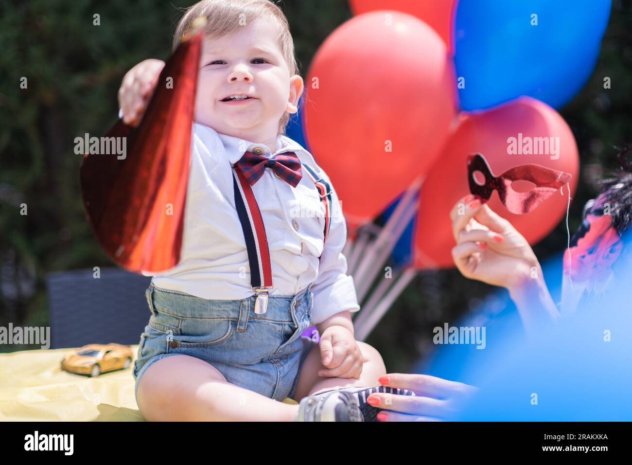 Premier anniversaire bébé d'un an, avec chapeau Happy Birthday, fête ornée de ballons rouges et bleus Banque D'Images