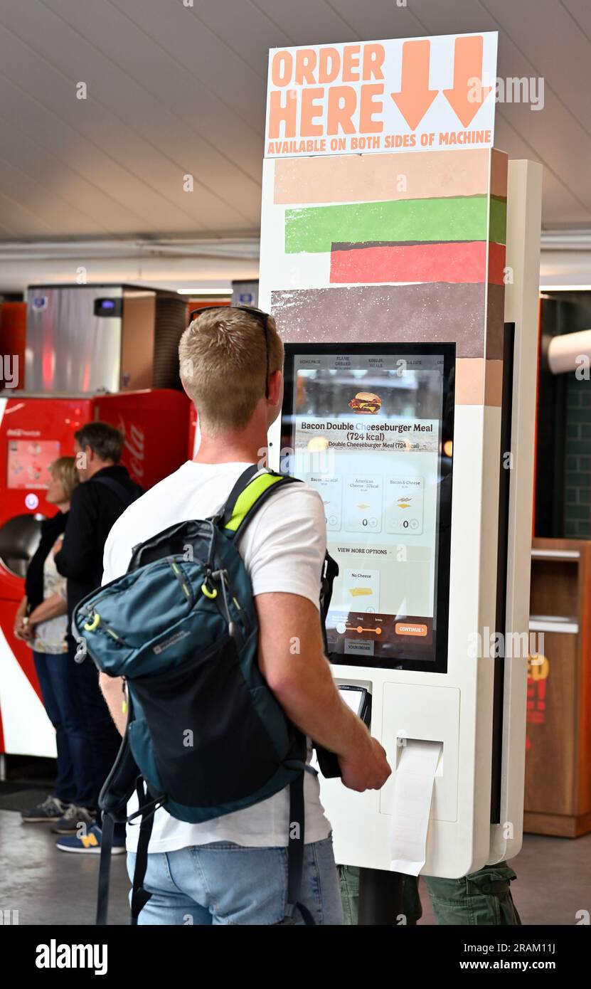 Homme sélectionnant des aliments au menu de commande de l'écran tactile électronique, Burger King Banque D'Images