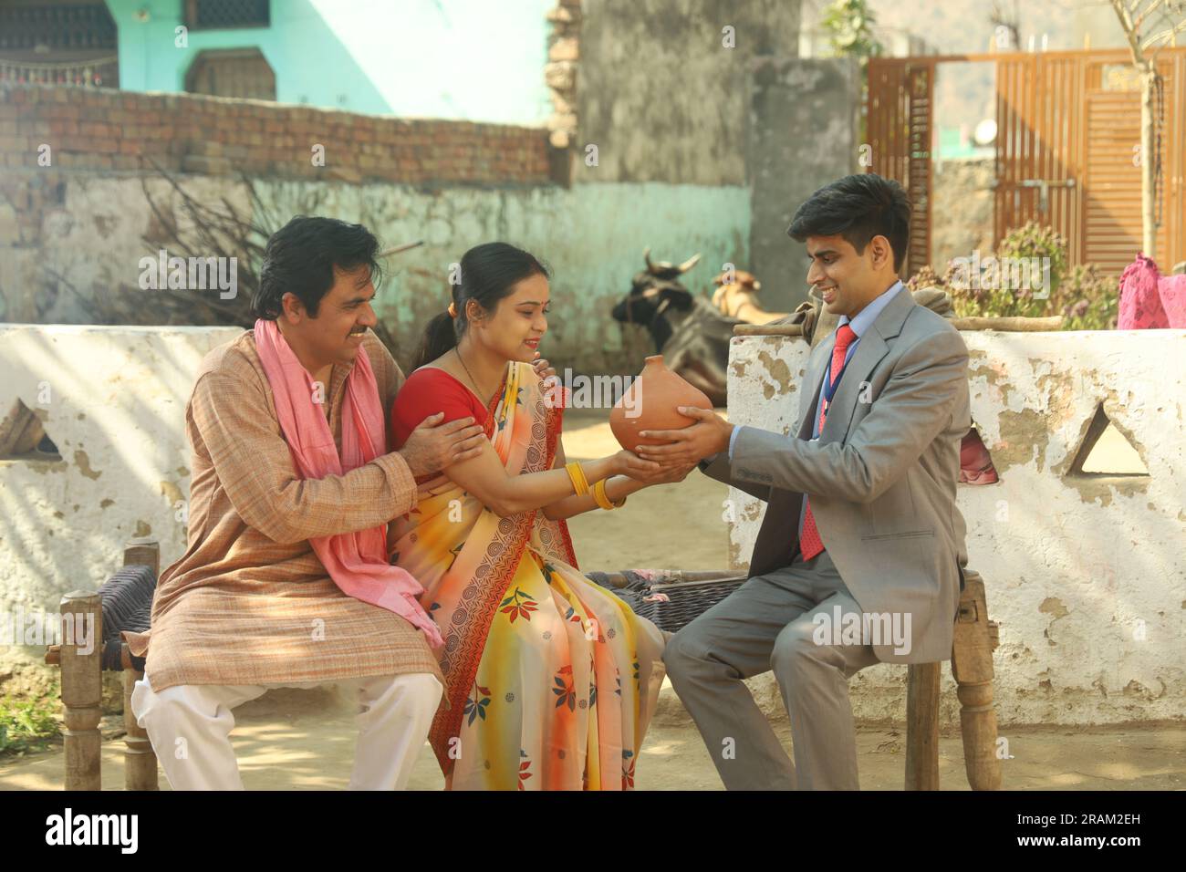 Femme tenant le Piggy Bank avec son mari. Famille aspirative montrant de l'amour envers leur argent économisé. Directeur de banque leur passant la tirelire. Banque D'Images