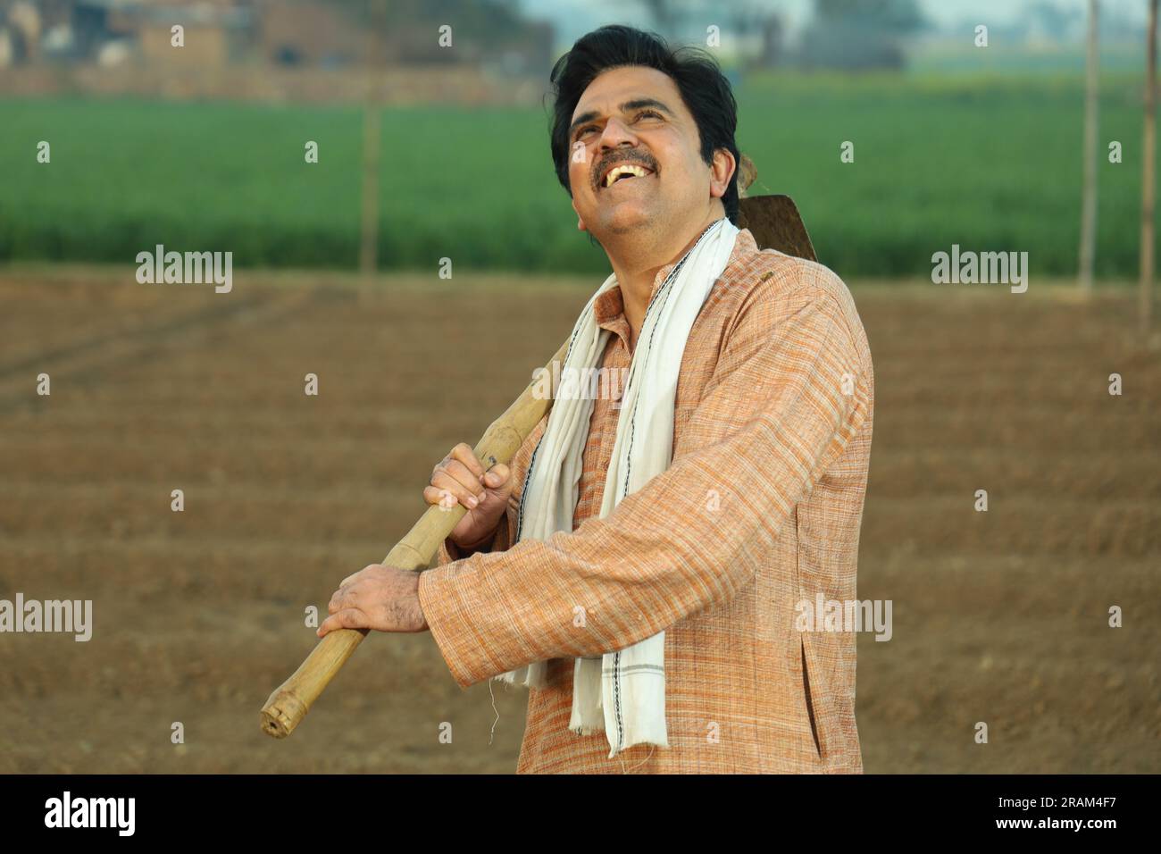 Portrait d'un fermier indien heureux labourant le champ manuellement en une journée. Tenir un outil agricole en main. Pelle et houe à outils de creusement en main. Banque D'Images