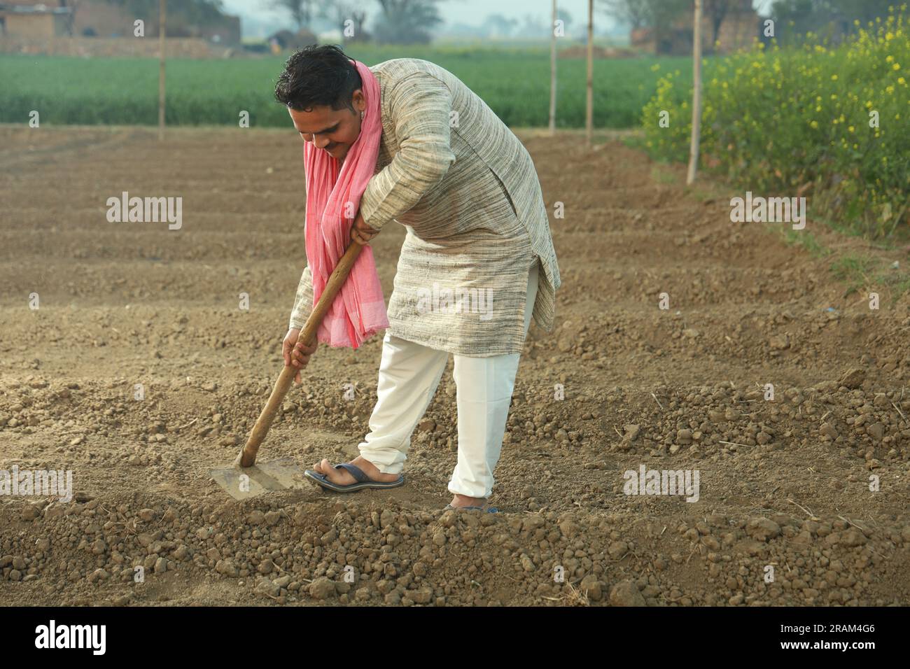 Portrait d'un fermier indien heureux labourant le champ manuellement en une journée. Tenir un outil agricole en main. Pelle et houe à outils de creusement en main. Banque D'Images