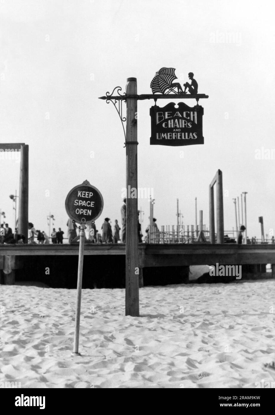 Long Island, New York : c. 1928. Des panneaux décoratifs uniques sont maintenant utilisés au parc national de Jones Beach. Celui-ci indique le chemin vers les chaises de plage et les parasols. Banque D'Images