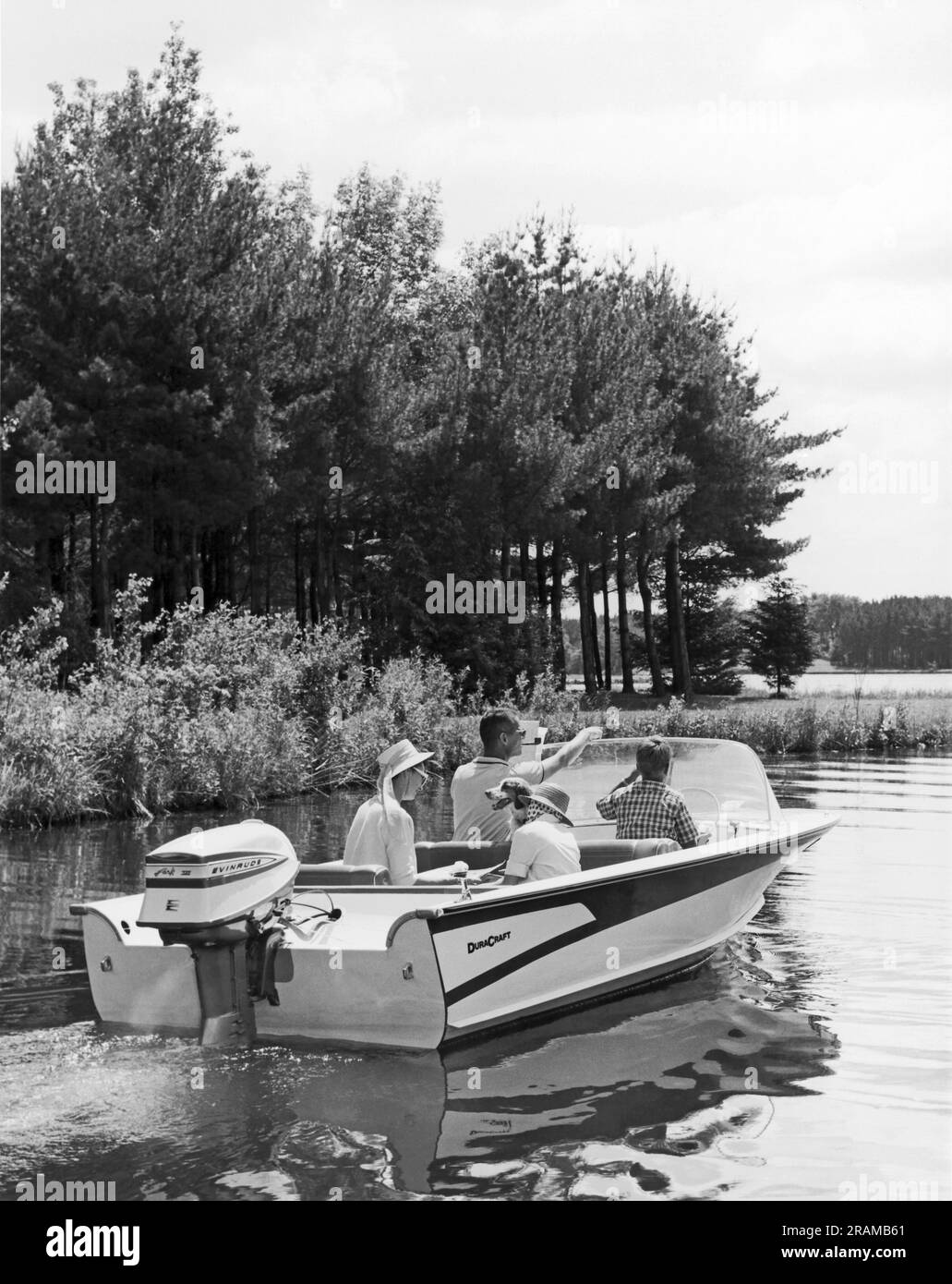 États-Unis c. 1960 Une famille et son chien profitent d'une promenade en bateau sur un lac Banque D'Images