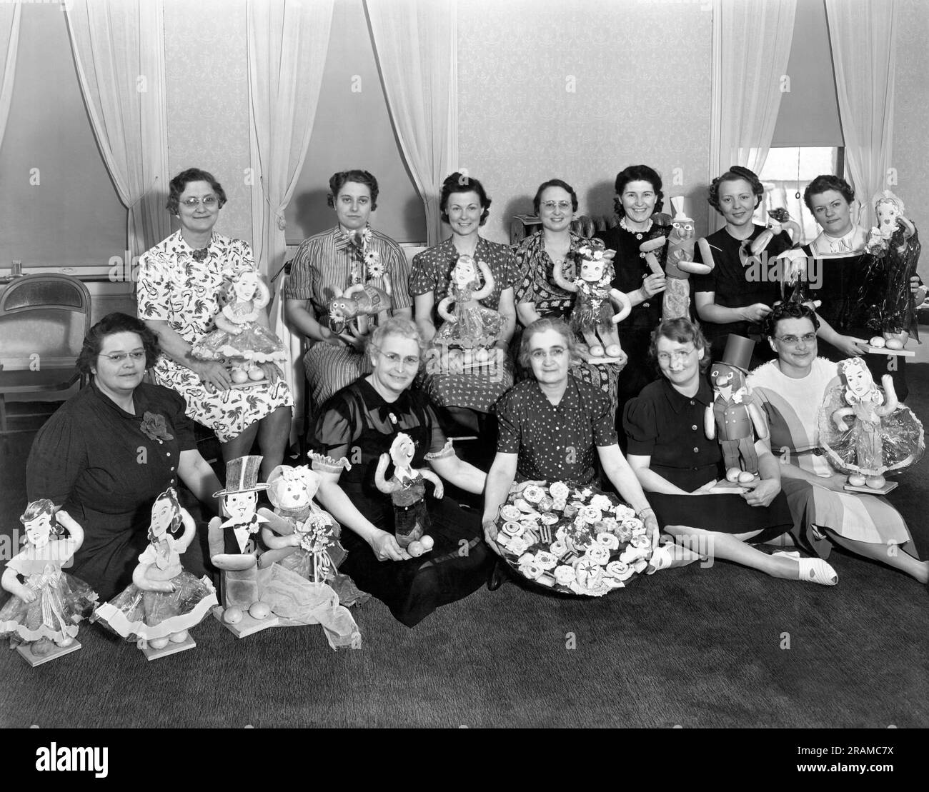 États-Unis : c. 1948 vue d'un groupe de femmes d'âge moyen qui tiennent leurs créations de poupées faites à la main. Banque D'Images