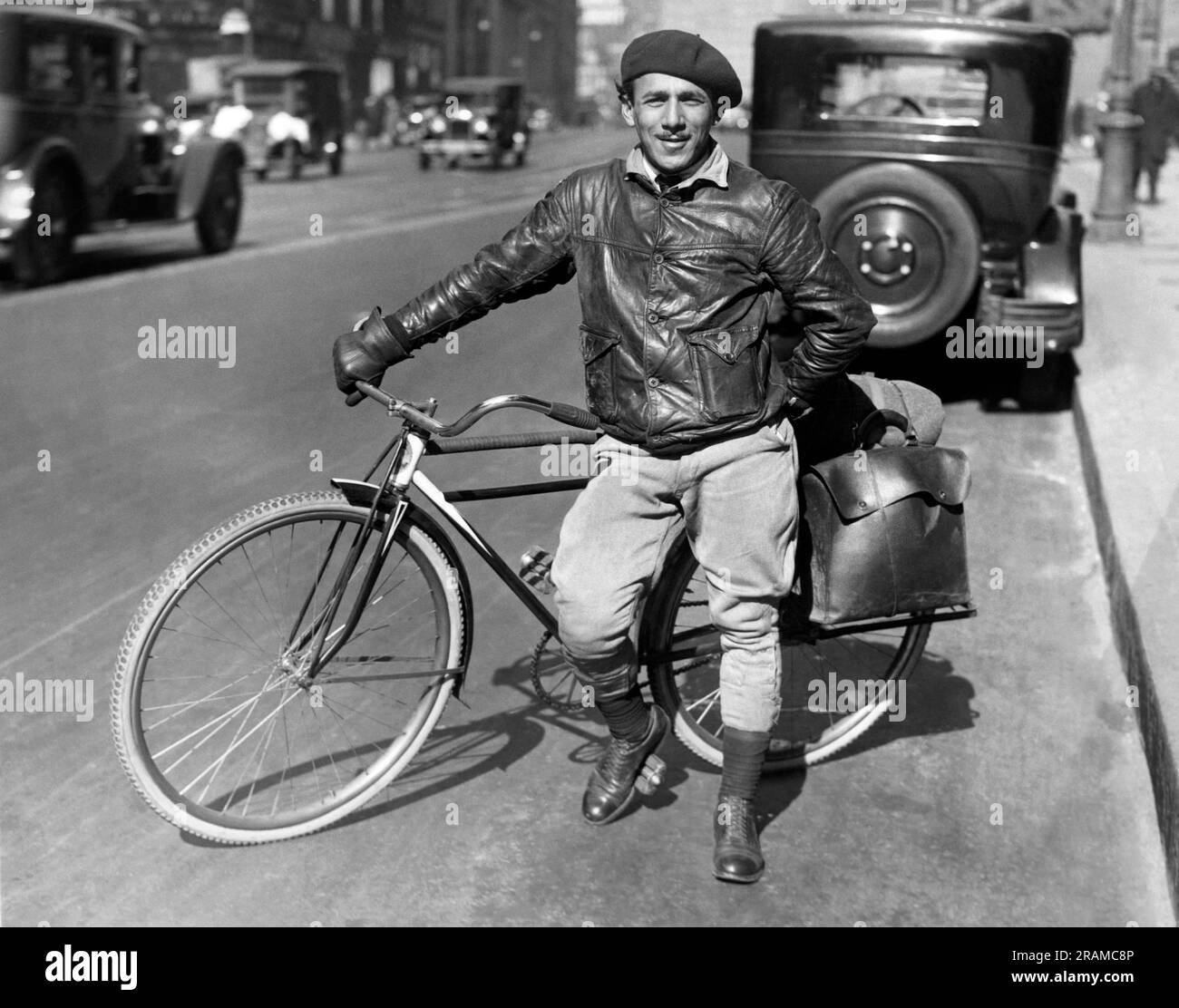 New York, New York: c. 1926 Un homme avec un vélo pour voyager équipé de sacs de selle à l'arrière. Banque D'Images