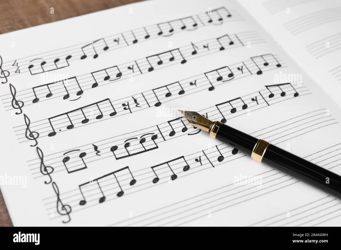 Feuille avec notes de musique et stylo plume sur la table, gros plan Banque D'Images