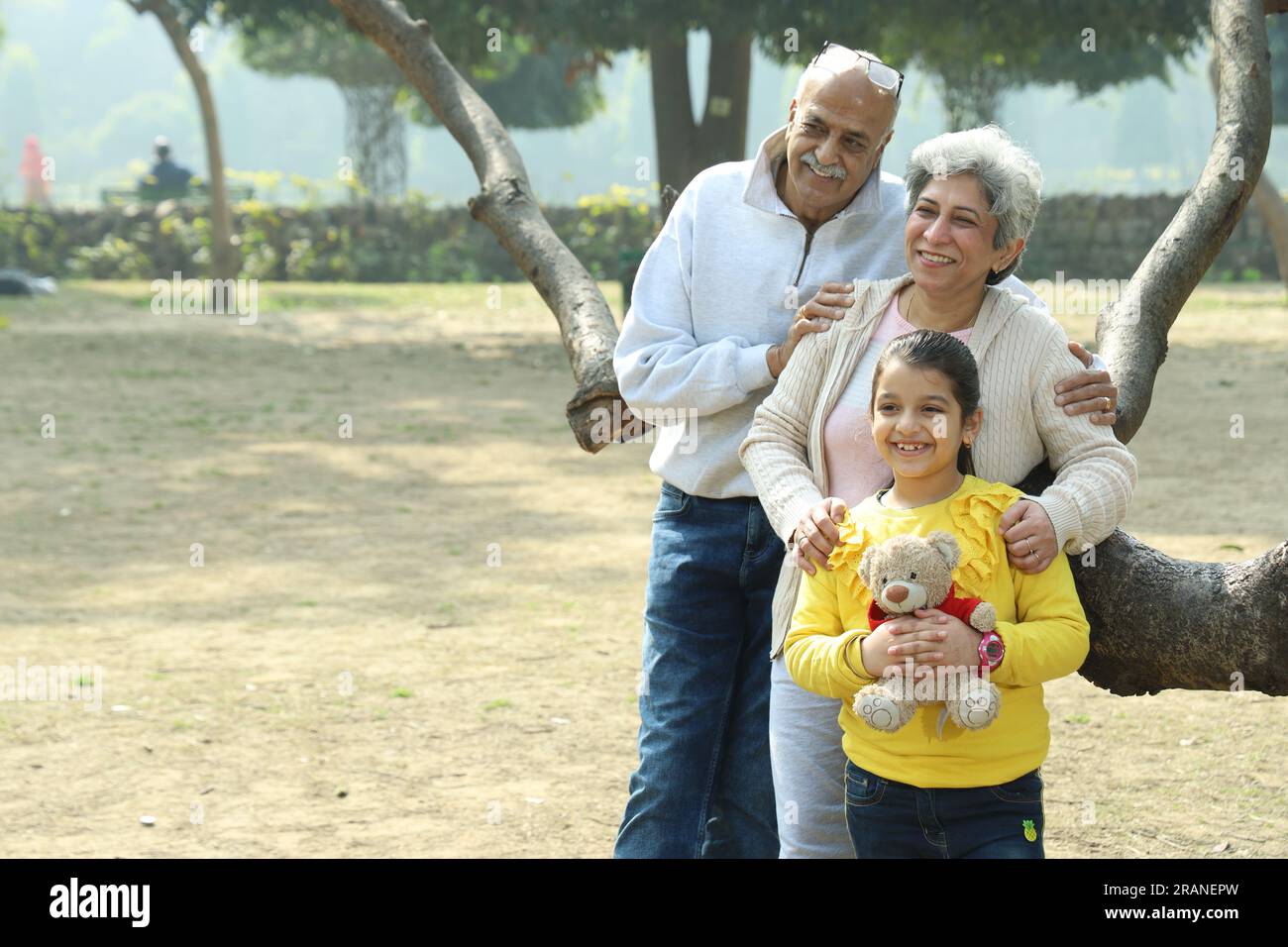 Grand-père appréciant avec petite-fille dans un parc entouré de verdure et de sérénité. Ils passent un moment joyeux et joyeux ensemble Banque D'Images