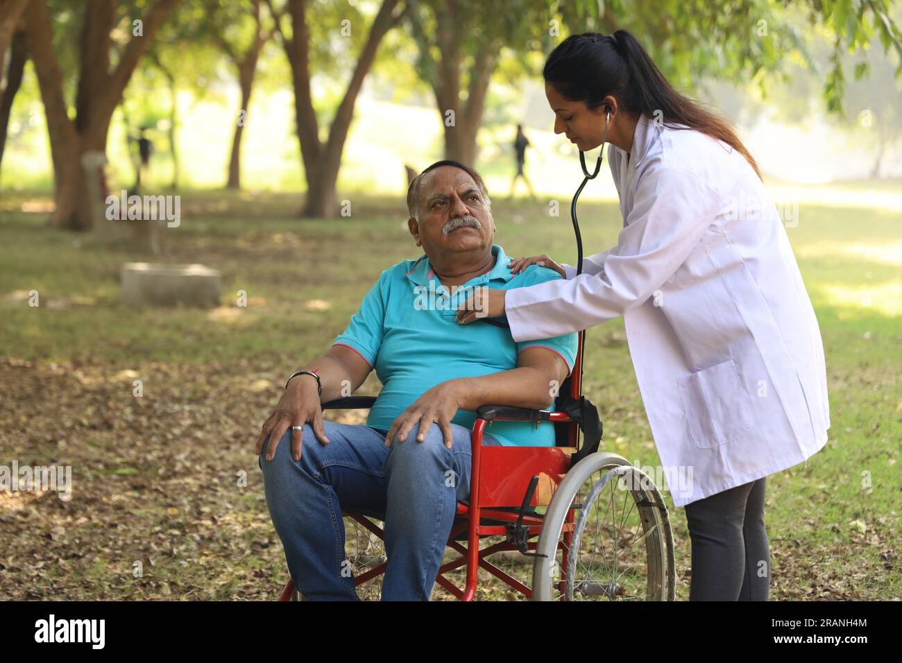 Médecin prenant soin du patient âgé dans le jardin de l'hôpital. Le patient est incapable de marcher et de se faire soigner par un médecin de famille spécialisé Banque D'Images