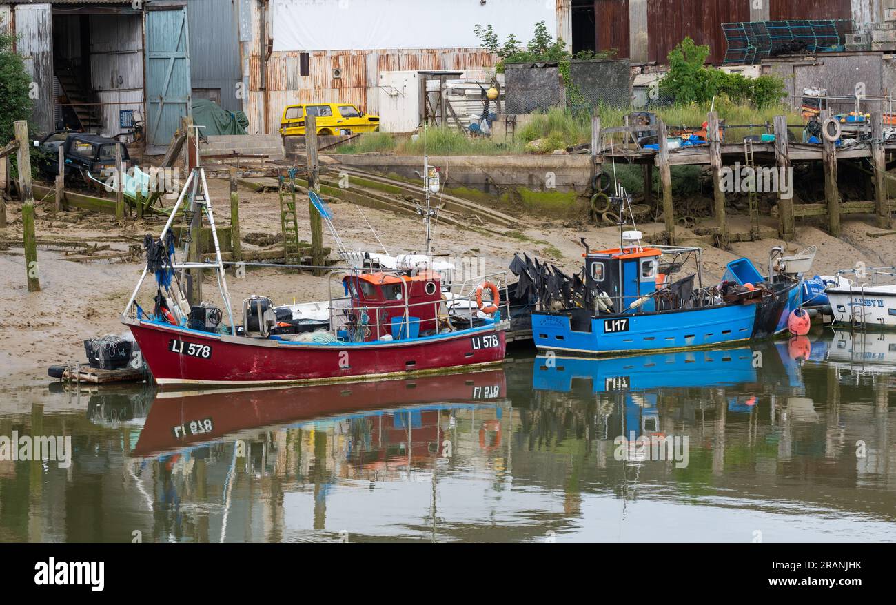 Amarré ou amarré de petits bateaux de pêche ou bateaux de pêche sur la rivière Arun à marée basse à Littlehampton, West Sussex, Angleterre, Royaume-Uni. Banque D'Images