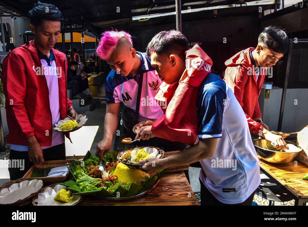 Bandung, Java Ouest, Indonésie. 5 juillet 2023. Azka Ahyadi, (deuxième à partir du milieu a les cheveux roses) joueurs de l'équipe nationale indonésienne pour la coupe du monde des sans-abri (HWC 2023) et leurs coéquipiers prennent de la nourriture lors de la libération de l'équipe nationale indonésienne. L’équipe nationale HWC Indonésie participera à la coupe du monde de Street soccer à Sacramento, aux États-Unis, le 8 juillet 2023. Crédit : Dimas Rachmatsyah/Alamy Live News Banque D'Images