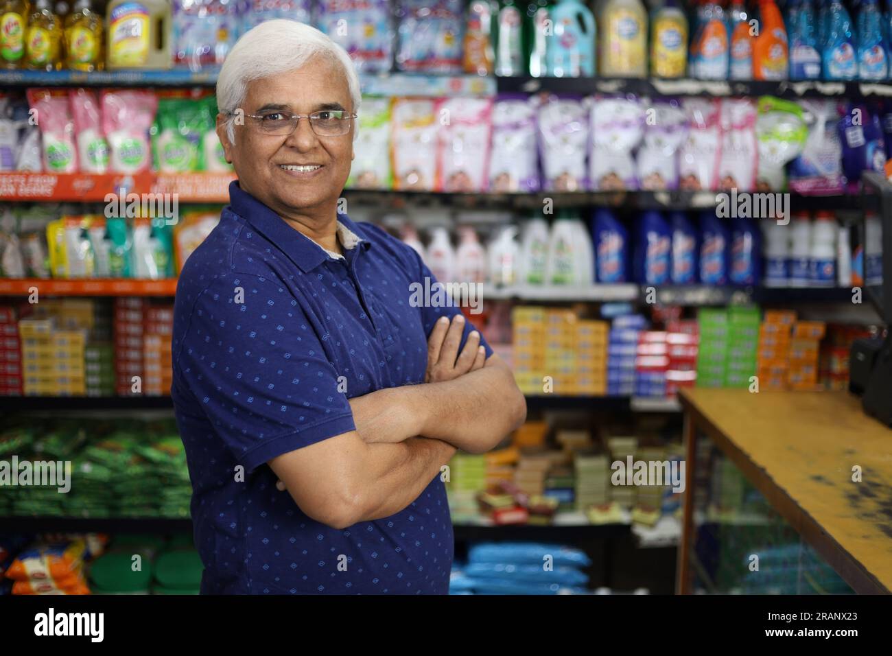 Portrait d'un homme de vieillesse indien heureux et souriant achetant dans une épicerie. Confiant et en forme grand-père achetant l'épicerie pour la maison dans un supermarché. Banque D'Images