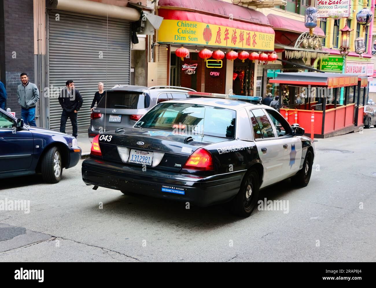 Vue arrière d'une voiture de police du San Francisco police Department conduisant lentement dans Chinatown Grant Avenue San Francisco California USA Banque D'Images