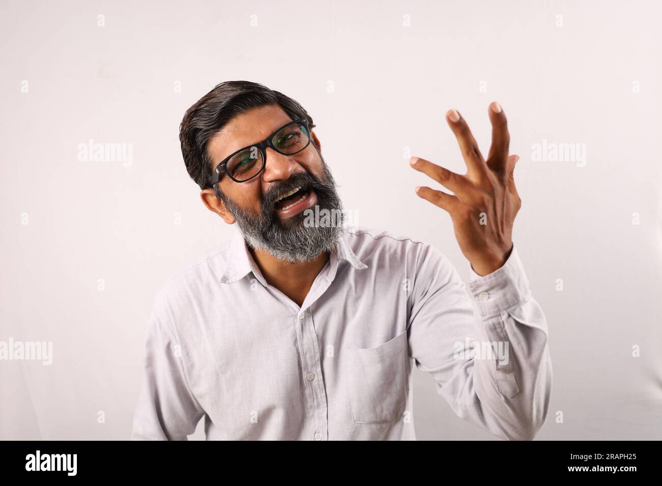 Portrait d'un homme barbu indien portant une chemise. Expressions funky illustrant le sens de l'accomplissement et de la réussite. Se sentir fier d'exécuter les choses. Banque D'Images