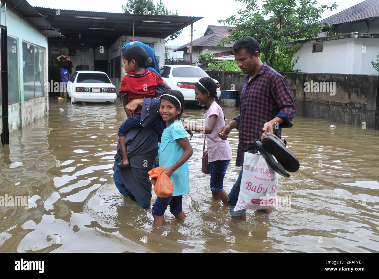 Les gens font leur chemin pendant les fortes pluies. Les pluies incessantes de ces derniers jours ont causé des problèmes d’engorgement à travers Sylhet, avec de nombreuses routes submergées. En raison d'un développement non planifié et d'un système de drainage médiocre, ces zones gorgées d'eau sont inondées pendant les fortes pluies et même les pluies légères, disent les habitants. Sylhet, Bangladesh. Banque D'Images