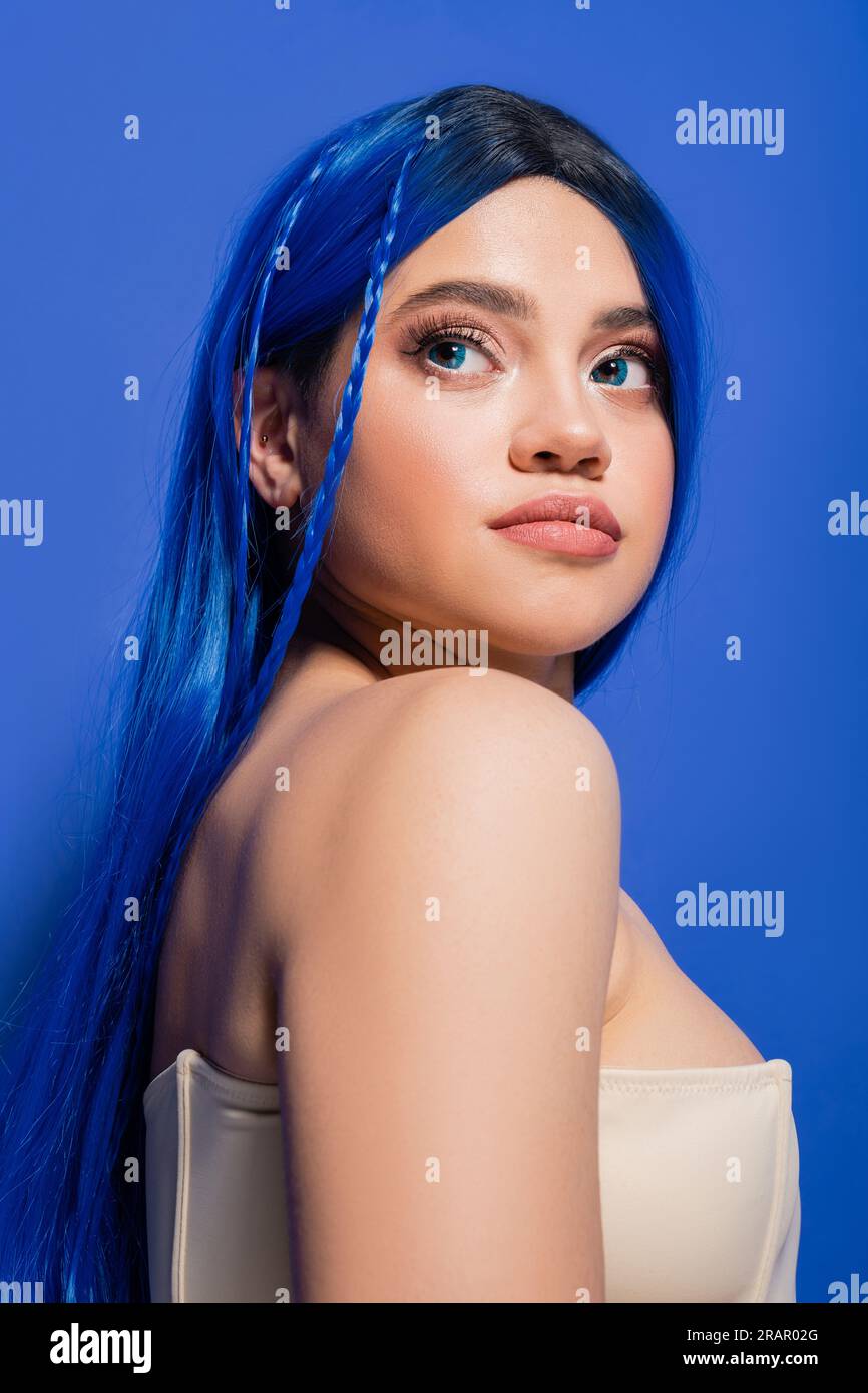 photographie de beauté, jeune femme avec les cheveux teints posant sur fond bleu, couleur des cheveux, peau brillante, modèle féminin avec maquillage et coiffure à la mode, vib Banque D'Images