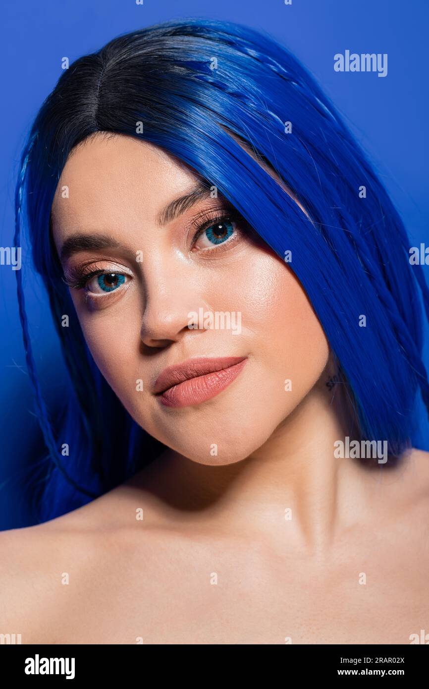 portrait, beauté et concept de jeunesse, jeune femme aux cheveux teints posant sur fond bleu, couleur des cheveux, individualisme, modèle féminin avec maquillage et tren Banque D'Images