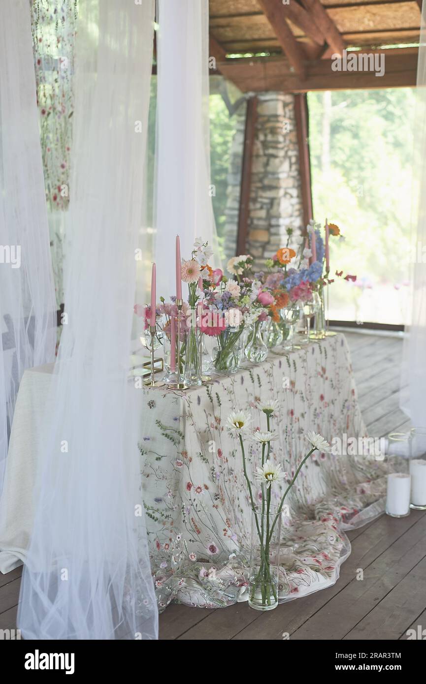 Floristique. Décoration florale du mariage dans des couleurs pastel. Beaucoup de fleurs dans différents vases et récipients Banque D'Images