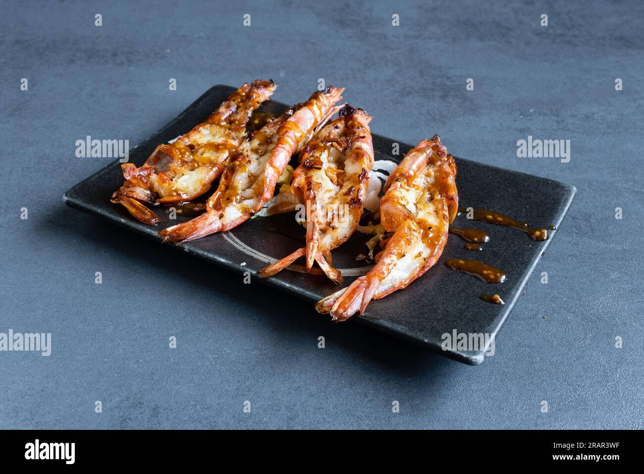 Restaurant de sushi, vue sur un plat japonais grillé, crevettes grillées. Banque D'Images