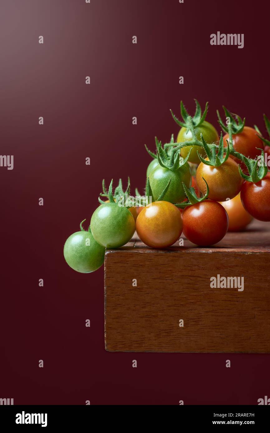 gros plan de tomates cerises sur un dessus de table, variété populaire de tomates largement consommée dans le monde entier, petits fruits en bouchée avec du sucré Banque D'Images