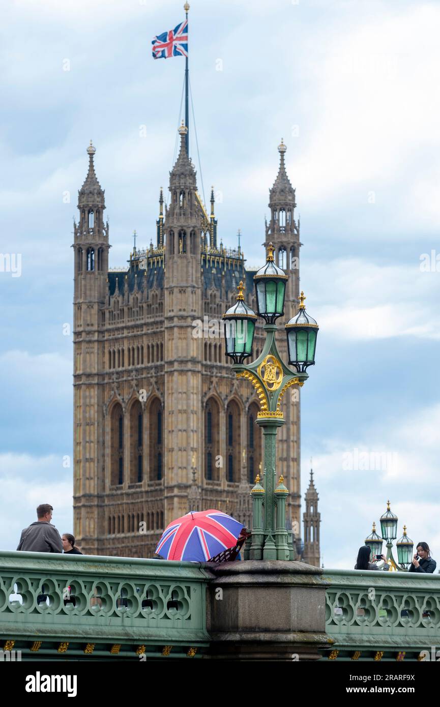 Londres, Royaume-Uni. 5 juillet 2023. Les touristes passent devant un parapluie Union Jack sur Westminster Bridge. L'Organisation de coopération et de développement économiques (OCDE) a indiqué que le Royaume-Uni est aujourd'hui le seul pays du G7 à faire face à une inflation croissante. L'inflation au Royaume-Uni a augmenté à 7,9% en mai, contre 7,8% en avril, tandis que parmi les pays du G7, le taux a glissé à 4,6%, contre 5,4%. Crédit : Stephen Chung / Alamy Live News Banque D'Images