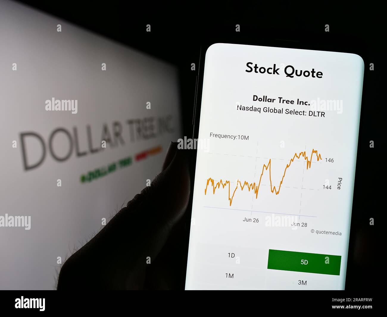 Personne tenant le téléphone cellulaire avec le site Web de la société de détail de rabais américaine Dollar Tree Inc. Sur l'écran devant le logo. Concentrez-vous sur le centre de l'écran du téléphone. Banque D'Images