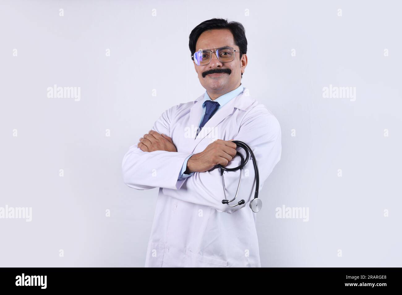 Portrait de médecin indien heureux en uniforme tenant stéthoscope et portant des spécifications. Docteur en moustache. Santé et médecin. Banque D'Images