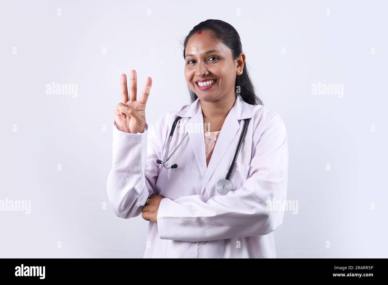 Portrait d'un médecin indien heureux en uniforme portant un stéthoscope. Stéthoscope. Docteur montrant trois doigts. Santé et médecin. Banque D'Images