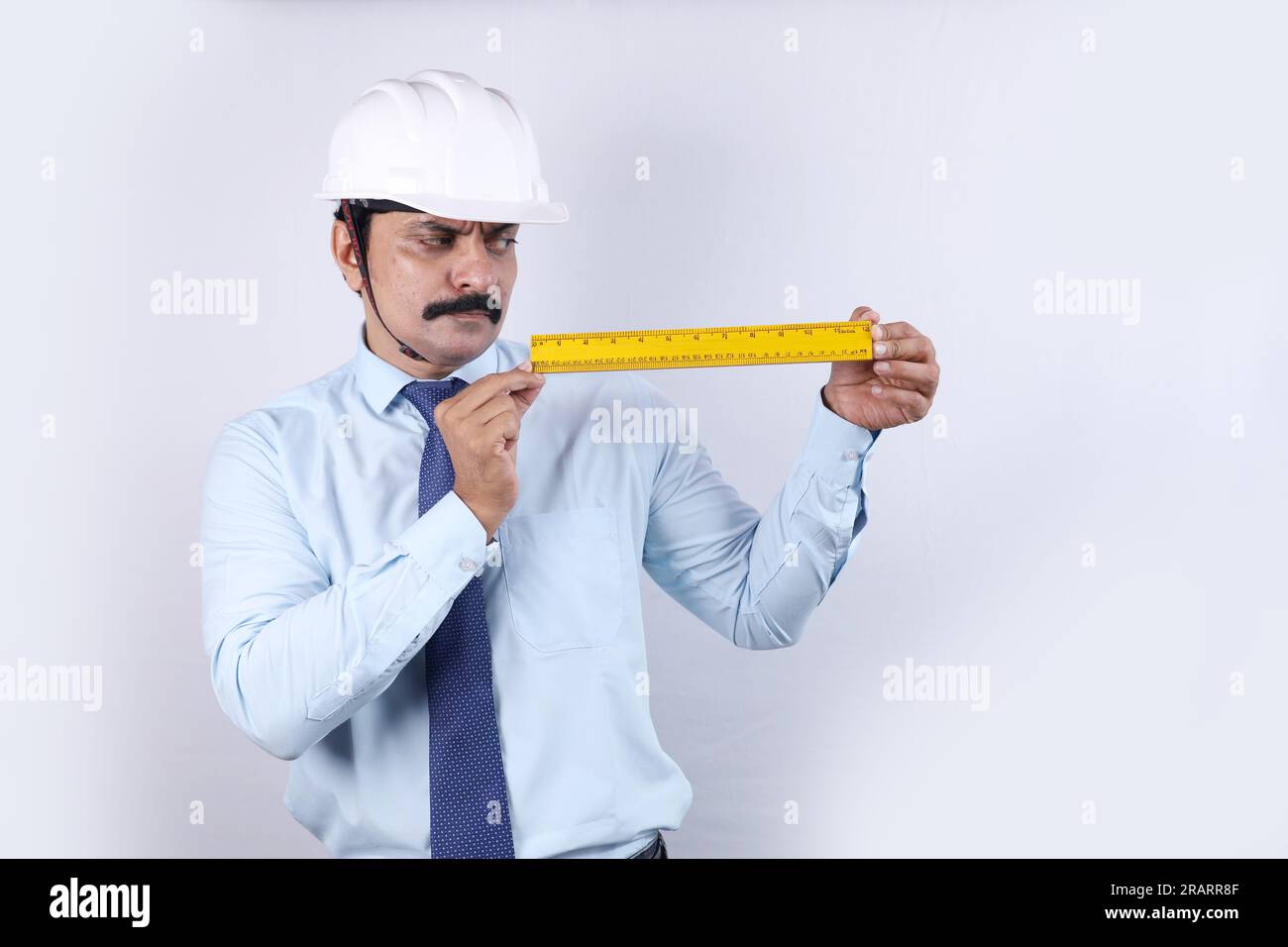 Heureux travailleur indien de construction faisant le concept d'ingénieur pour l'avenir. L'ingénieur joyeux porte un casque d'ingénierie. Graduation de mesure de maintien. Banque D'Images