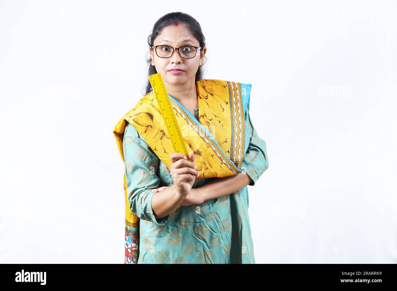 Professeur en tenue indienne. Portrait de Happy Indian Teacher tenant une échelle de mesure en main et des spécifications de port. Expressions diverses. Banque D'Images