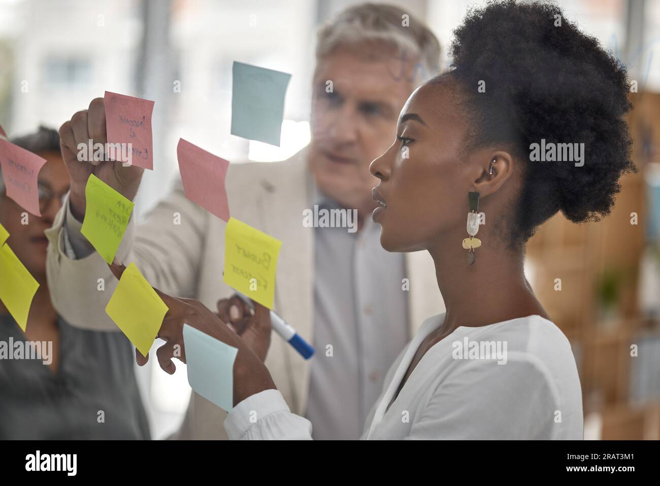 Réunion, planification et verre avec une femme noire menant une présentation dans une salle de conseil pour la stratégie de l'entreprise. Travail d'équipe, présentation et notes adhésives dans Banque D'Images