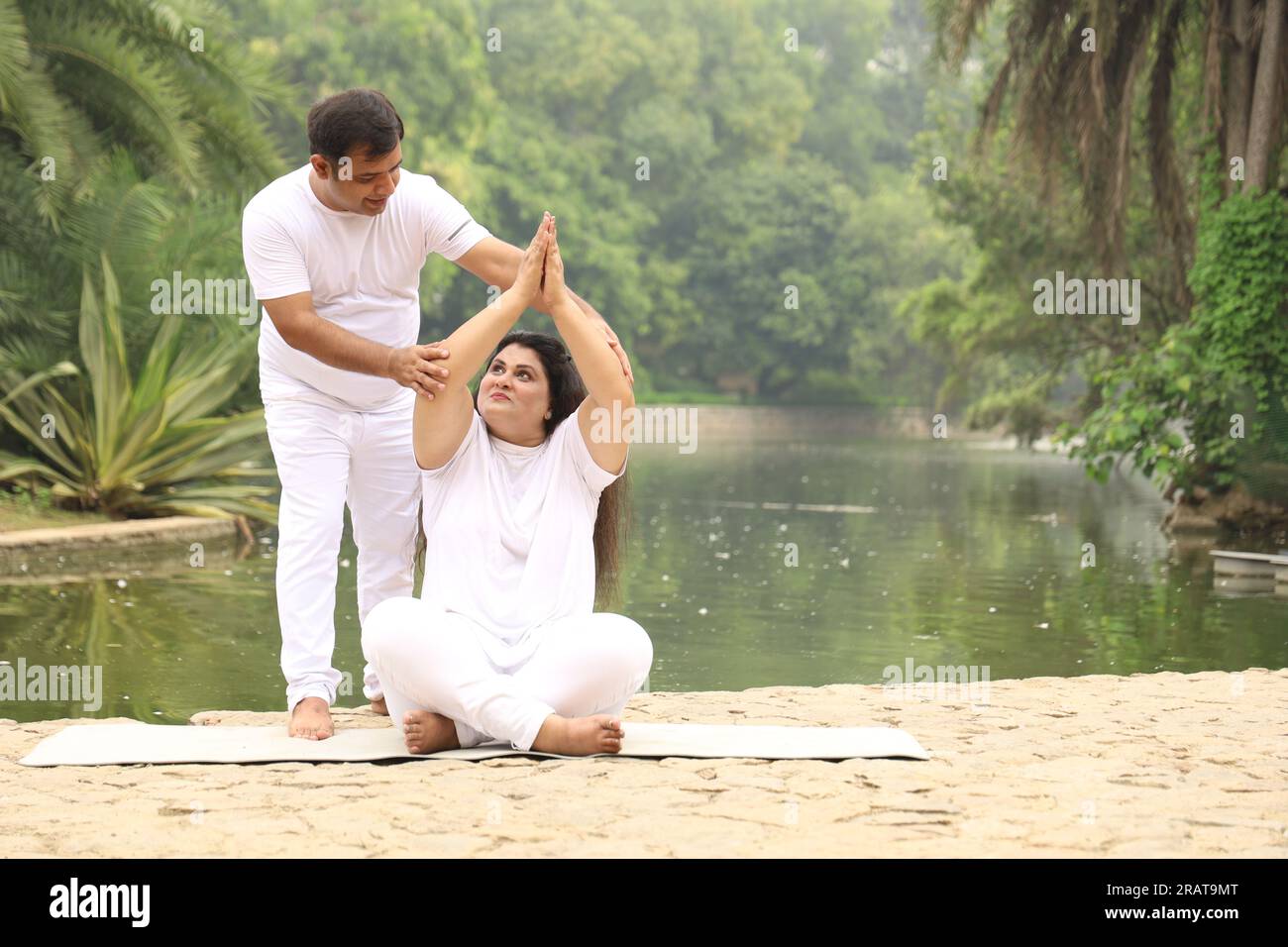 Couple obèse s'exerçant, pratiquant le yoga pose dans un environnement vert serein tôt le matin dans le parc pour maintenir un mode de vie sain. Journée internationale du yoga Banque D'Images