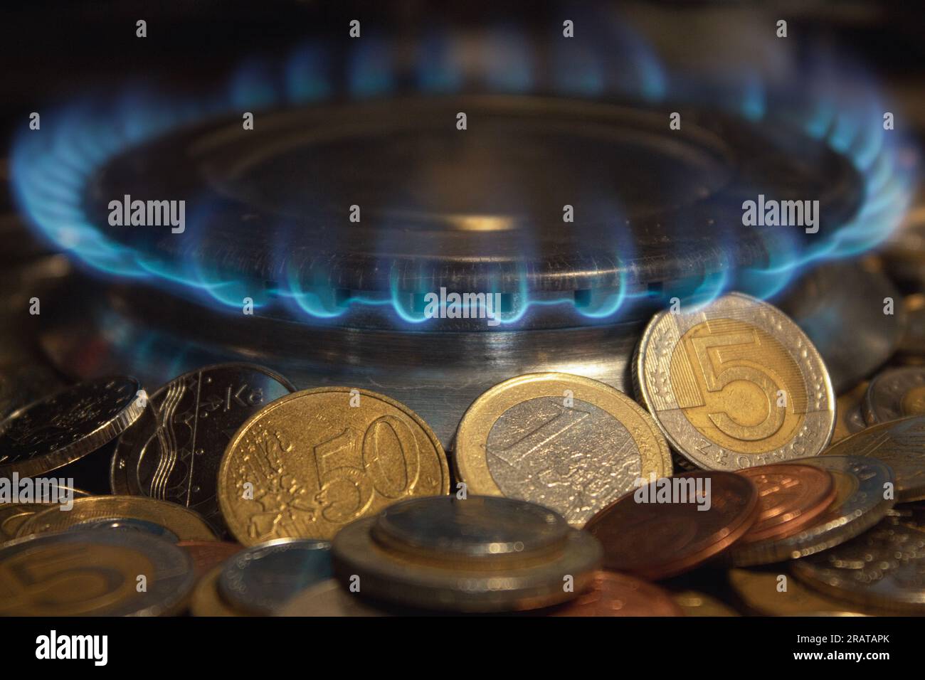 Flamme d'un brûleur à gaz, sur fond de pièces de monnaie. Concept. Augmentation des tarifs. Gaz coûteux, augmentation du prix du gaz. Un symbole de la hausse des prix du gaz Banque D'Images