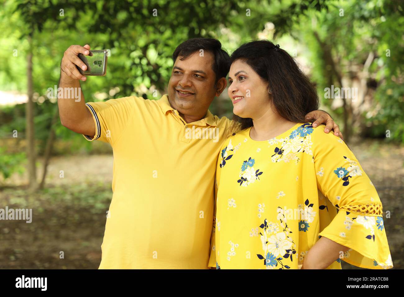 Couple indien obèse prenant selfie dans le parc tenant le téléphone portable en main. Banque D'Images
