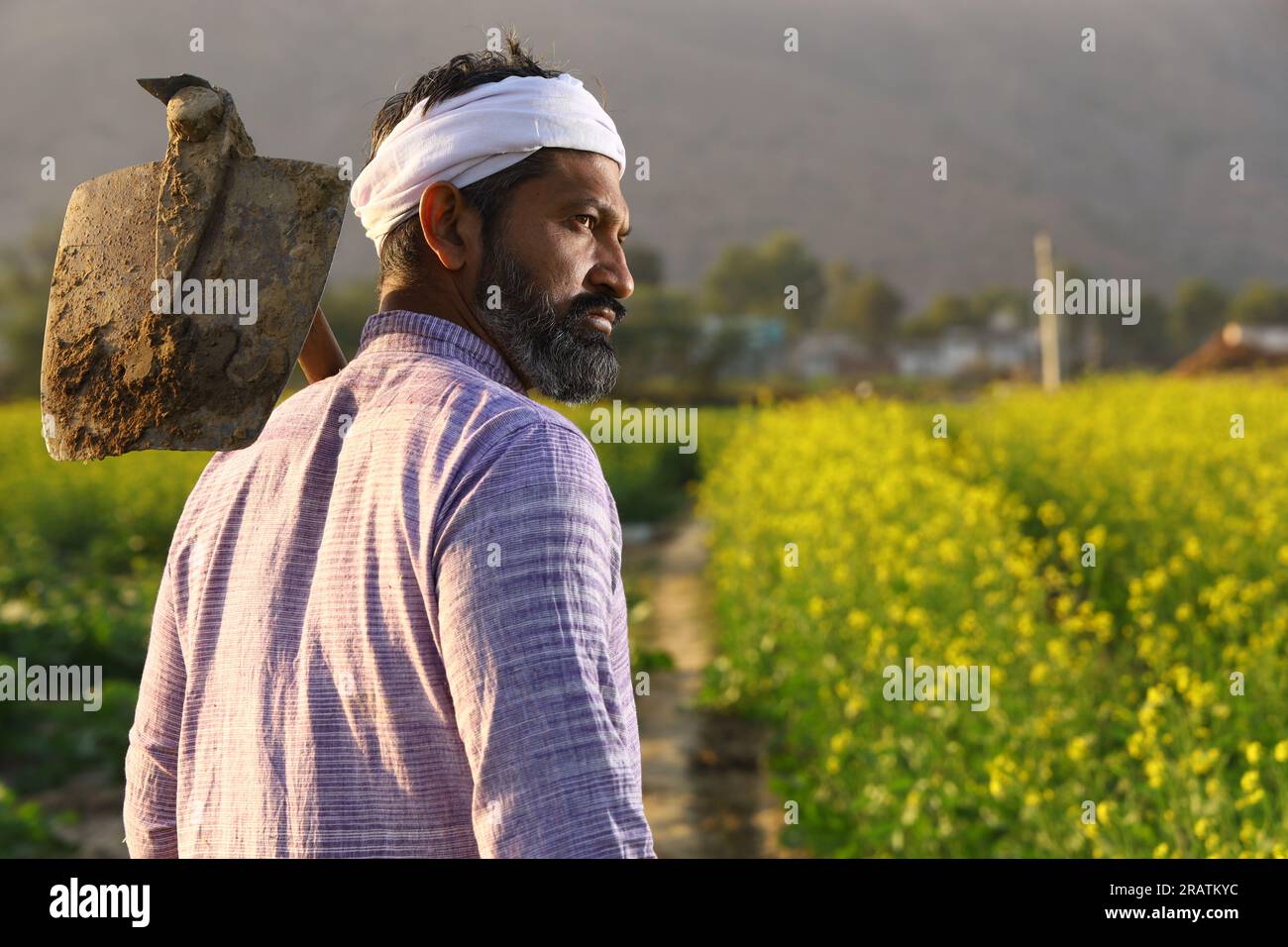 Fermier indien barbu en colère en turban debout avec une pelle à la main portant un pyjama Kurta. Banque D'Images