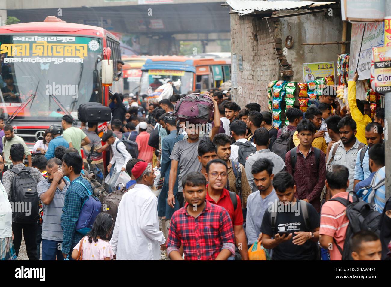 Les passagers se rassemblent à une station de bus alors qu'ils rentrent chez eux avant la fête musulmane de l'Aïd al-Adha à Dhaka, au Bangladesh, le 27 juin 2023. Banque D'Images