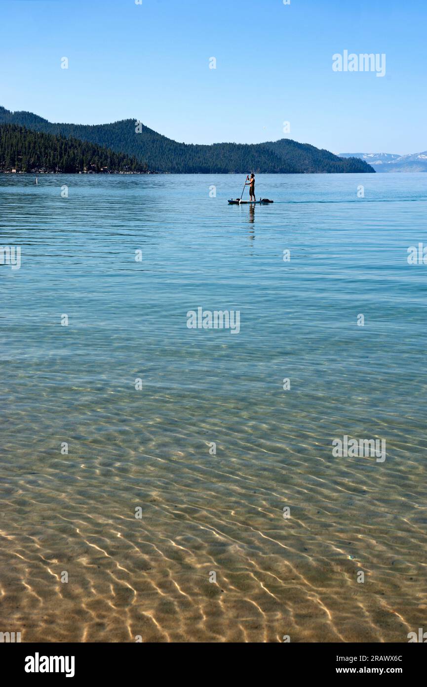 Un homme sur un paddle board à Sand Harbor à Lake Tahoe, Californie Banque D'Images