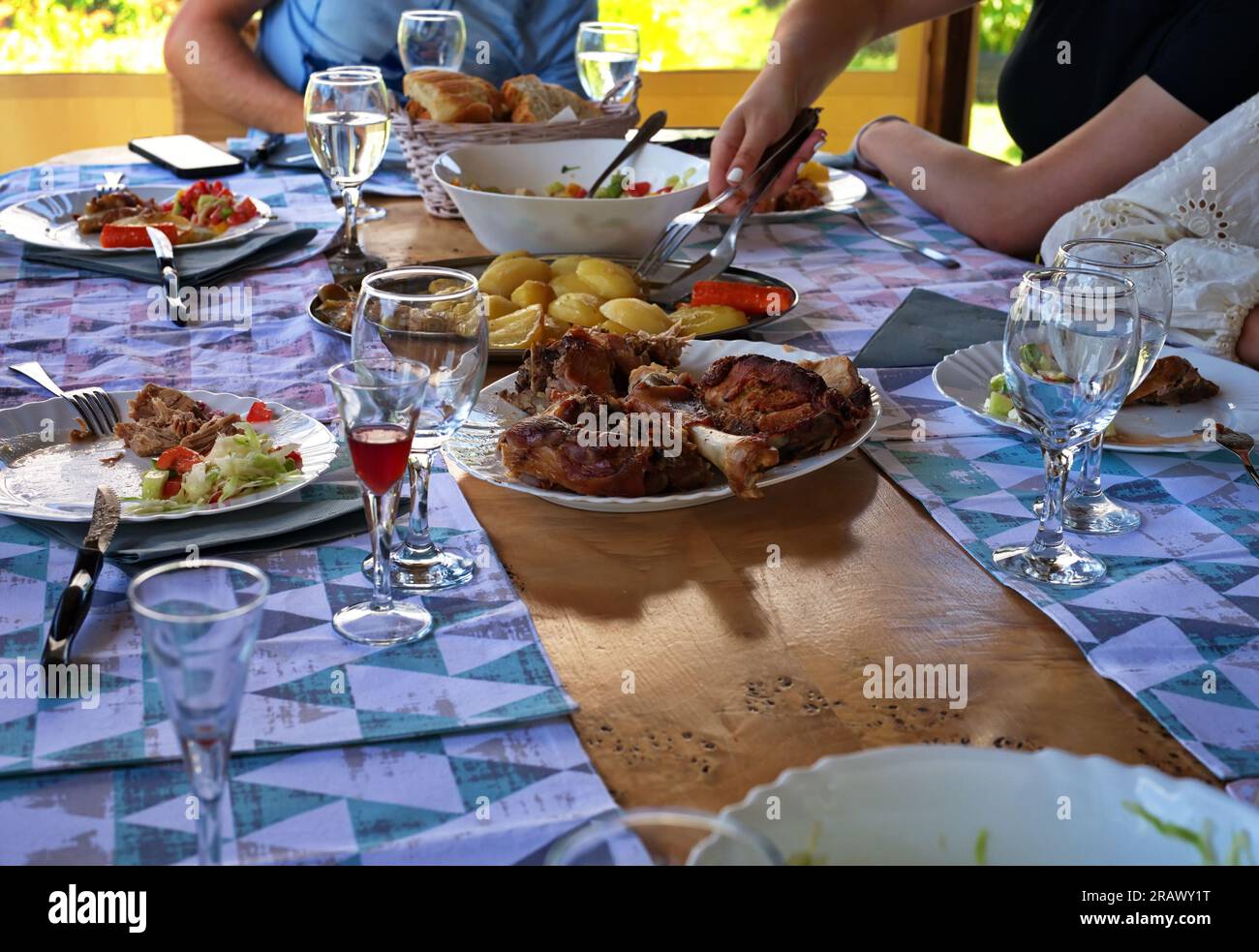 Section médiane des personnes mangeant à la table avec divers aliments et boissons Banque D'Images