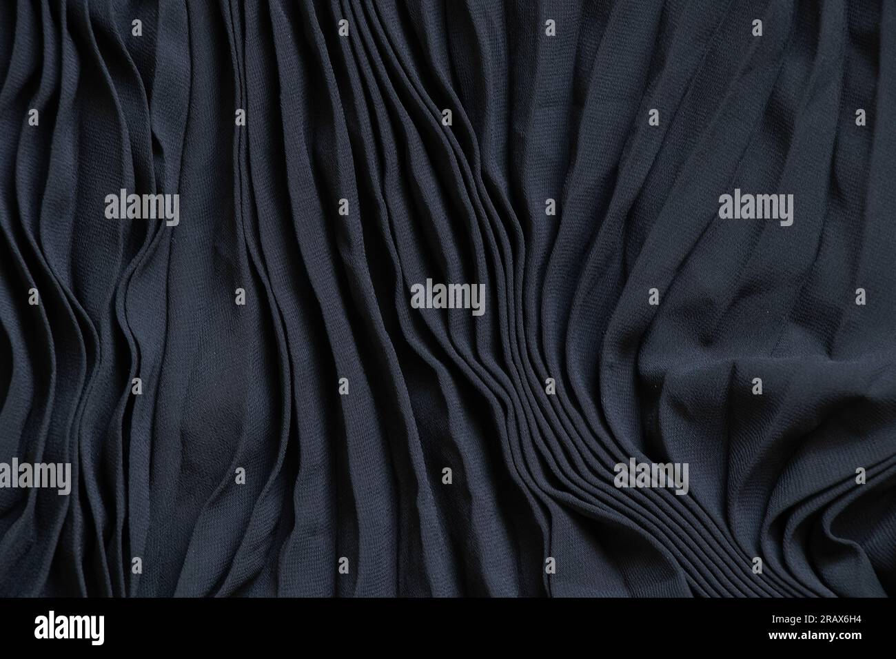 tissu noir uni plissé avec des lignes comme arrière-plan, le tissu est repassé avec des rayures Banque D'Images