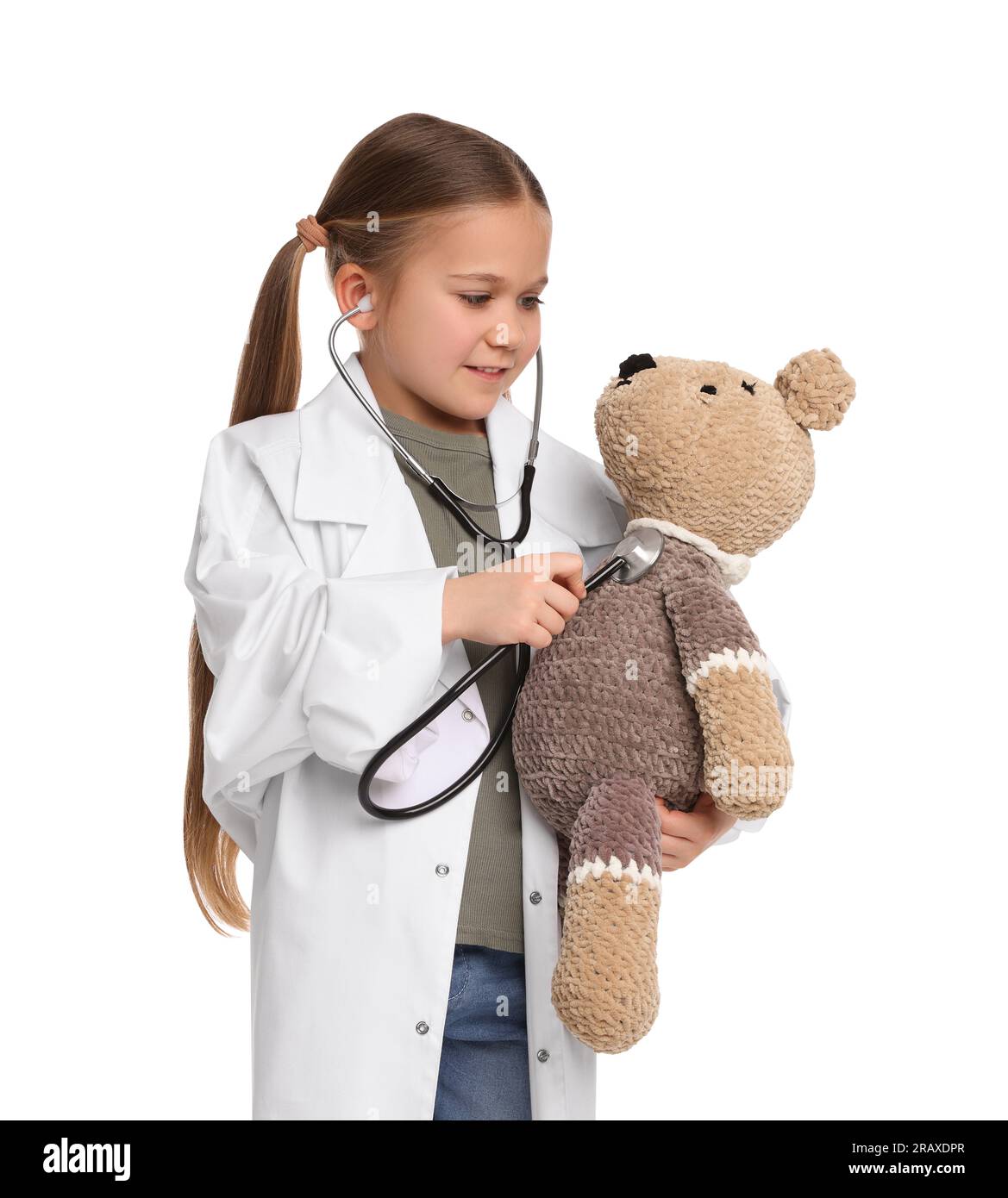 Petite fille jouant docteur avec ours jouet sur fond blanc Banque D'Images