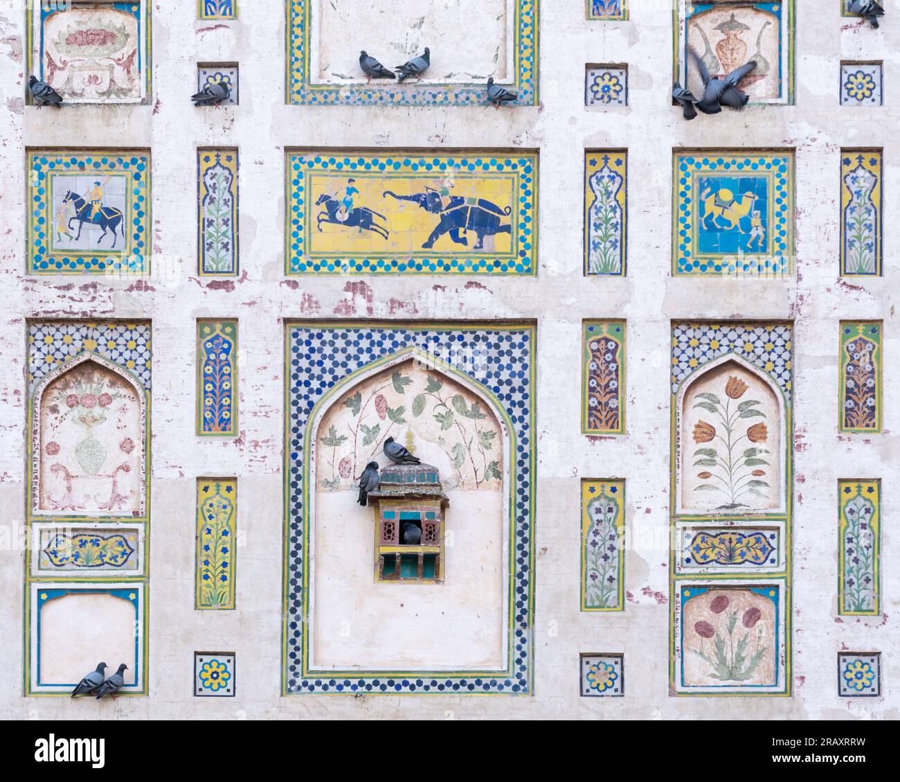 Détail du mur d'image coloré construit par l'empereur moghol Jahangir dans le fort de Lahore, Punjab, Pakistan avec de belles peintures et mosaïques et pigeons Banque D'Images