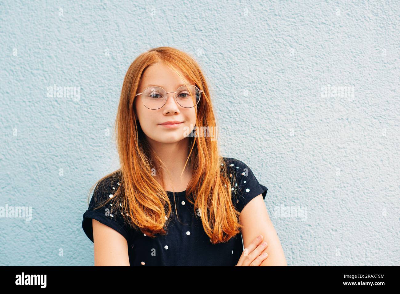 Portrait en plein air de petite fille douce avec les cheveux rouges, portant des lunettes Banque D'Images