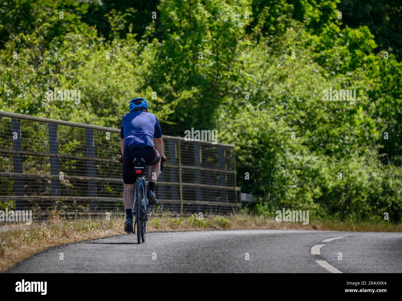 Cycliste traversant un pont sur l'autoroute M40 dans le Warwickshire, en Angleterre. Banque D'Images