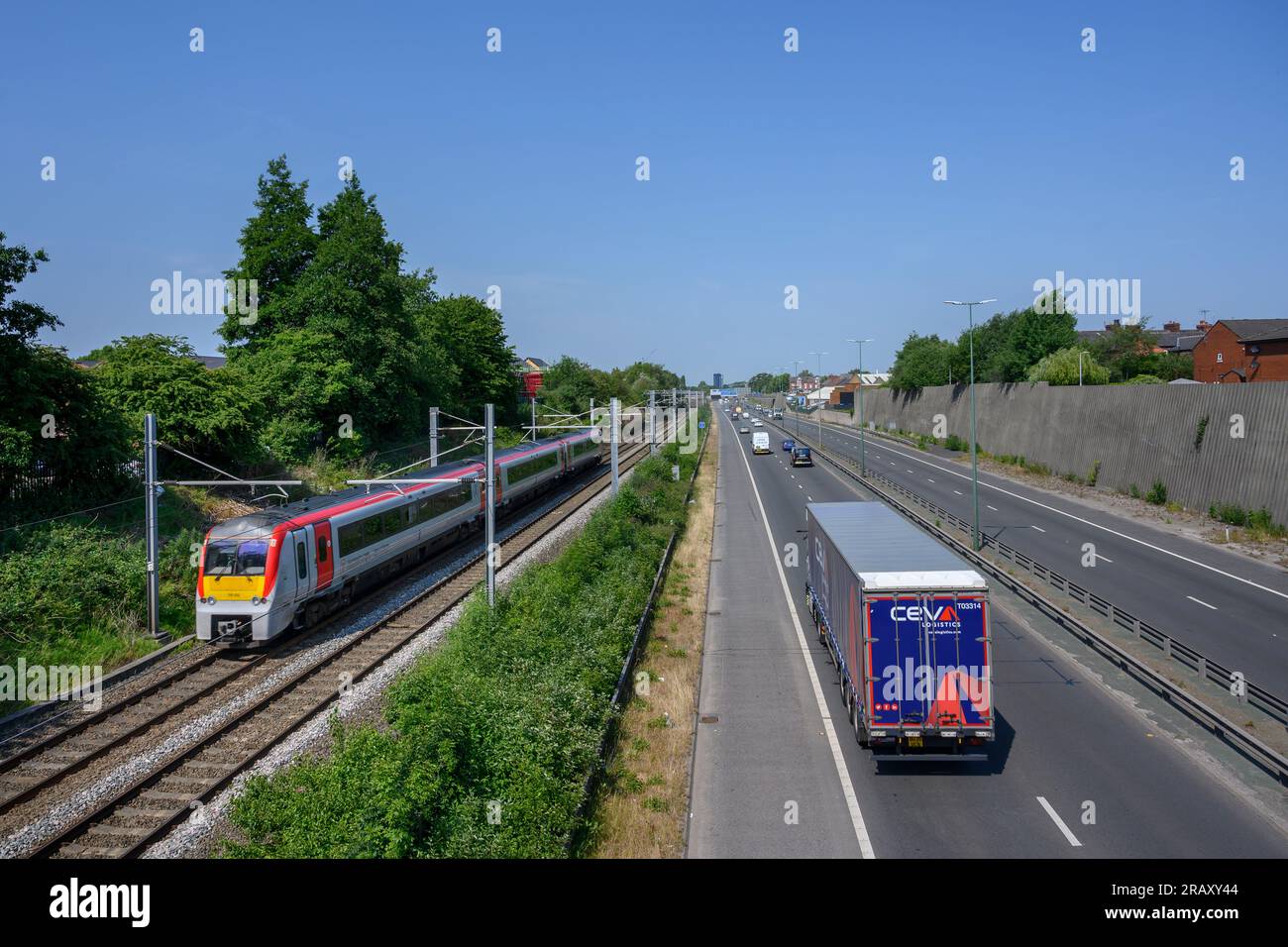 Transport pour le train du pays de Galles circulant sur une voie longeant une route à Salford, en Angleterre. Banque D'Images