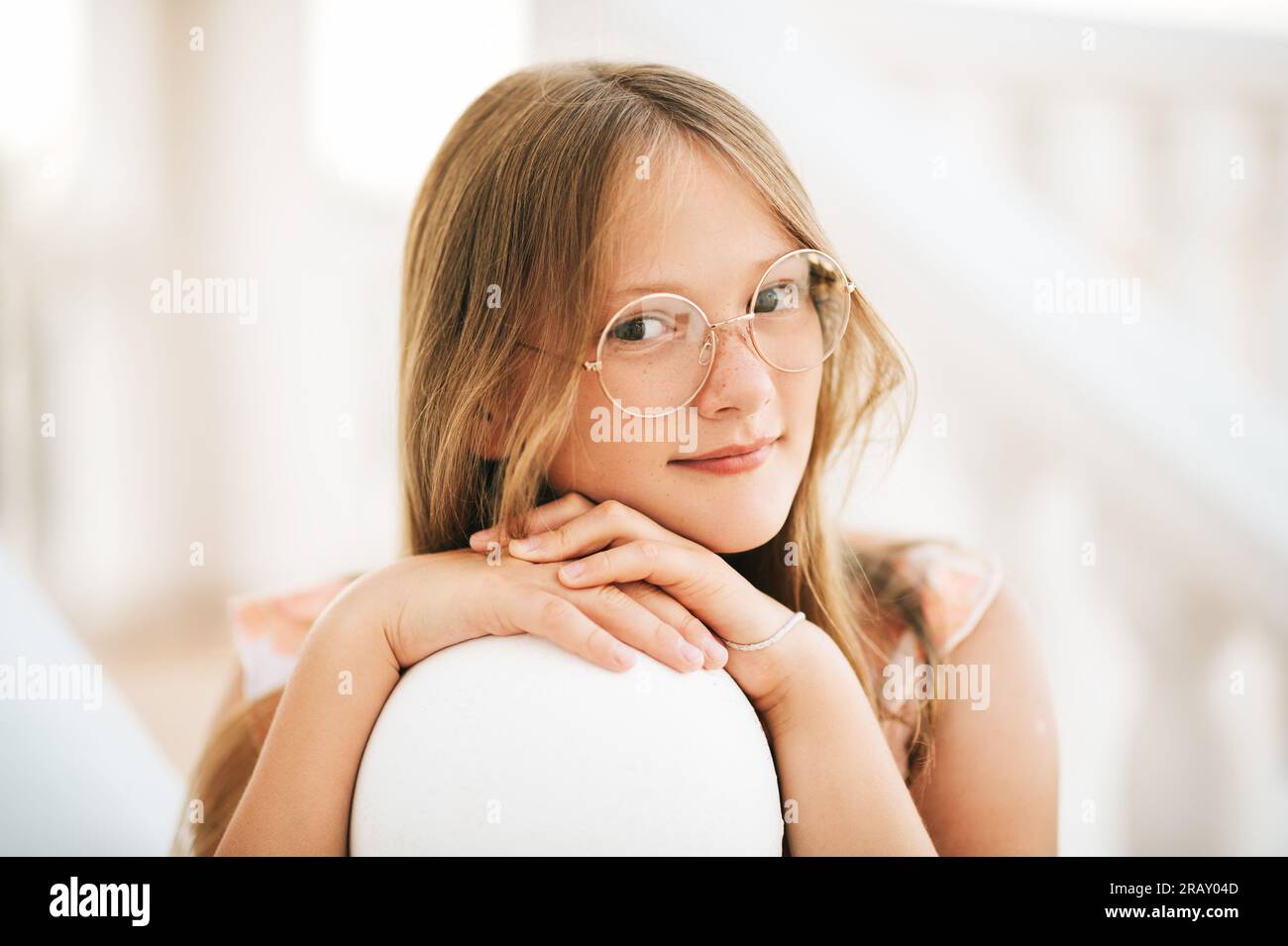 Portrait en plein air de belle jeune fille portant des lunettes, se penchant la tête sur les mains, image en gros plan Banque D'Images