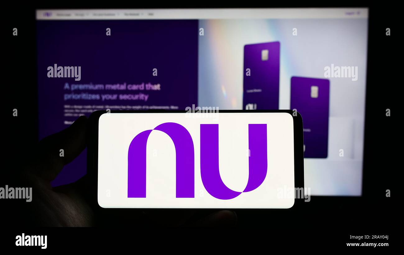 Personne tenant le smartphone avec le logo de la société brésilienne nu Pagamentos S.A. (Nubank) à l'écran devant le site Web. Concentrez-vous sur l'affichage du téléphone. Banque D'Images