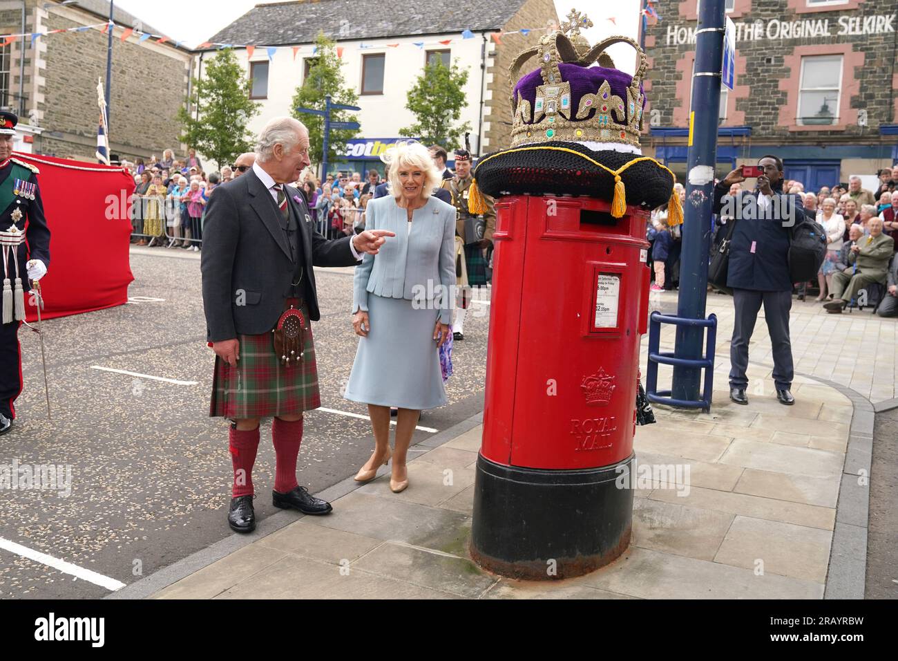 Le roi Charles III et la reine Camilla voient un surmontoir de boîte aux  lettres en crochet d'une couronne lors d'une visite de la place du marché à  Selkirk, dans les Scottish